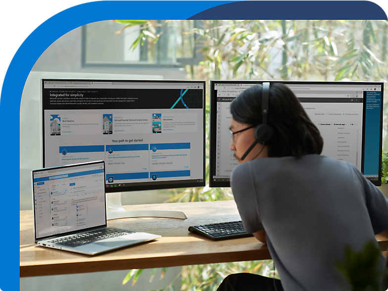 Donna seduta alla scrivania con due monitor davanti a lei.