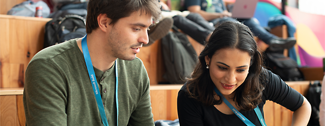 Due persone con sguardo rivolto verso il basso mentre guardano qualcosa