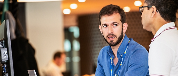 Due uomini in una sala riunioni che parlano tra loro.