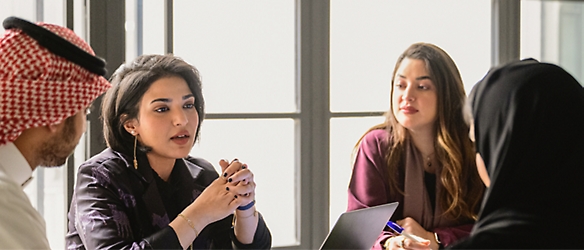 Un gruppo di persone che parlano sedute a un tavolo.