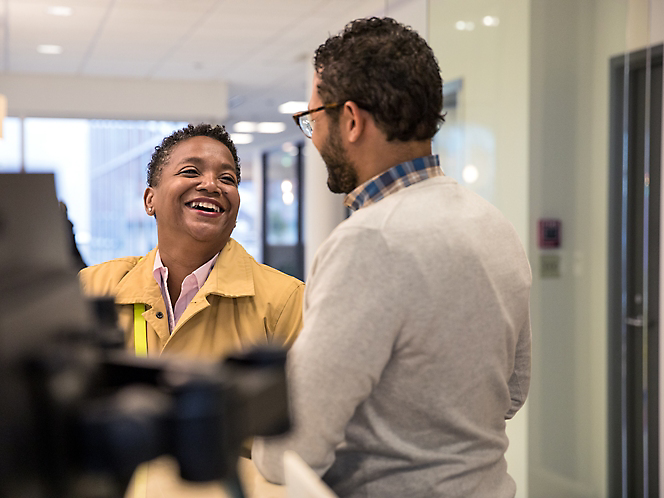 Un uomo e una donna che sorridono l'uno con l'altro in un ufficio.