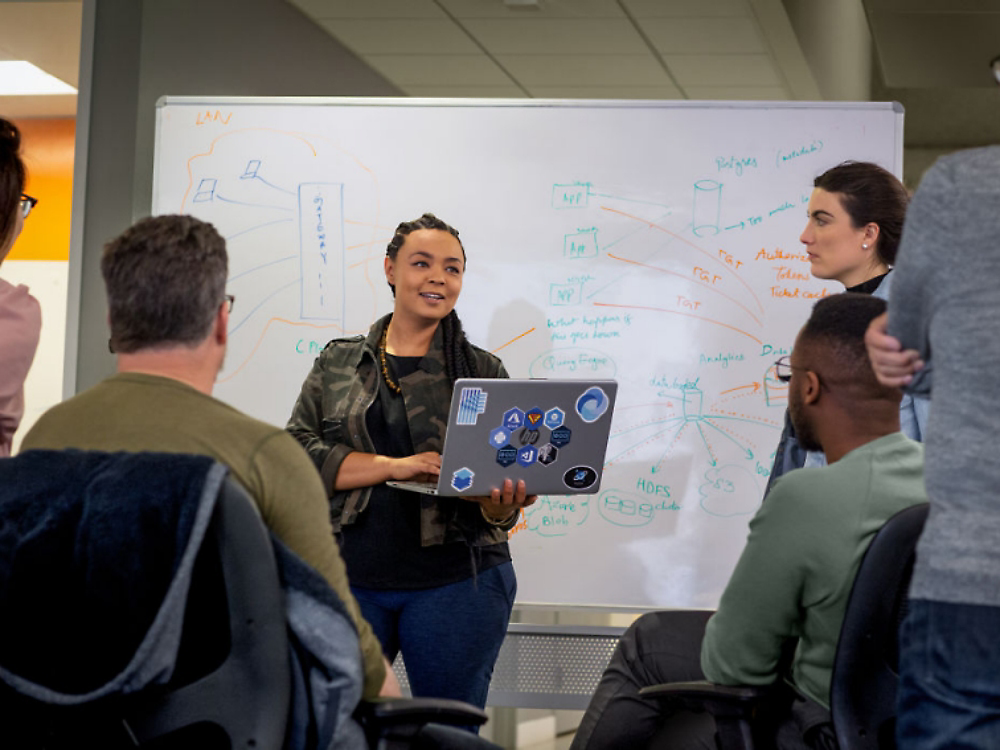 Una ragazza in piedi davanti a una stanza che tiene una presentazione