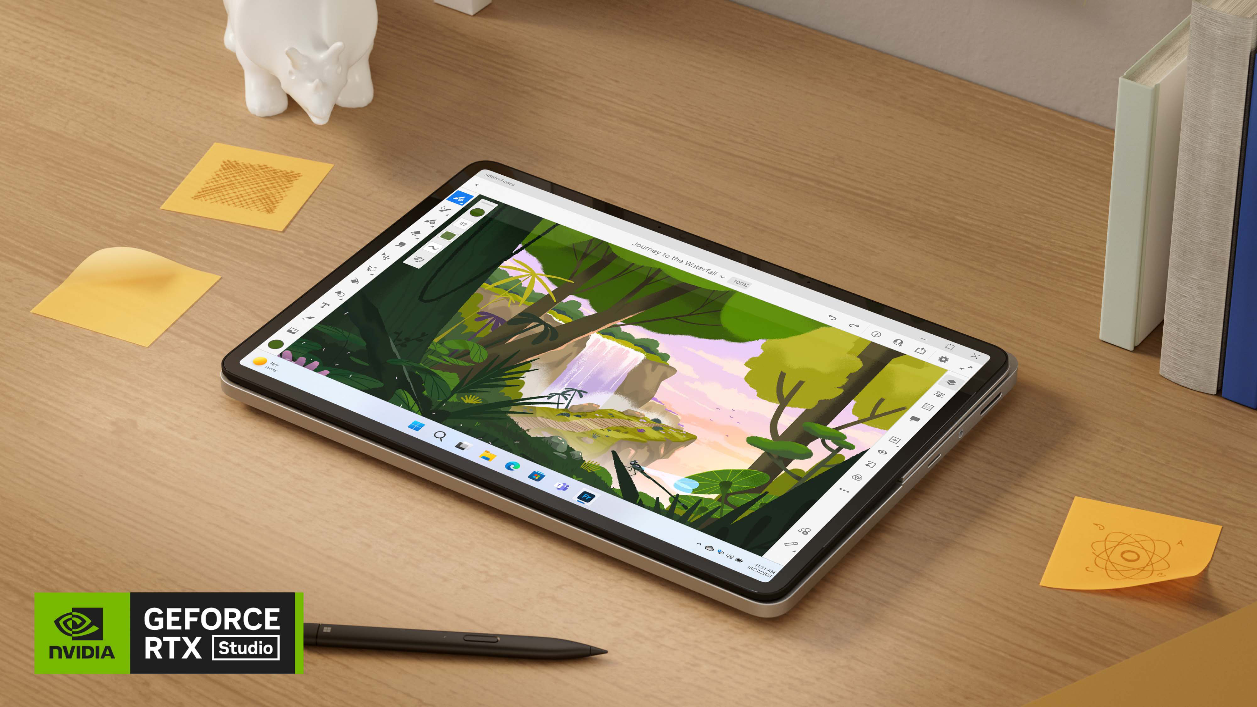 Un dispositivo Surface Laptop Studio 2 in modalità tablet su una scrivania in legno, con accanto una penna Surface Slim Pen 2 e alcuni post-it.