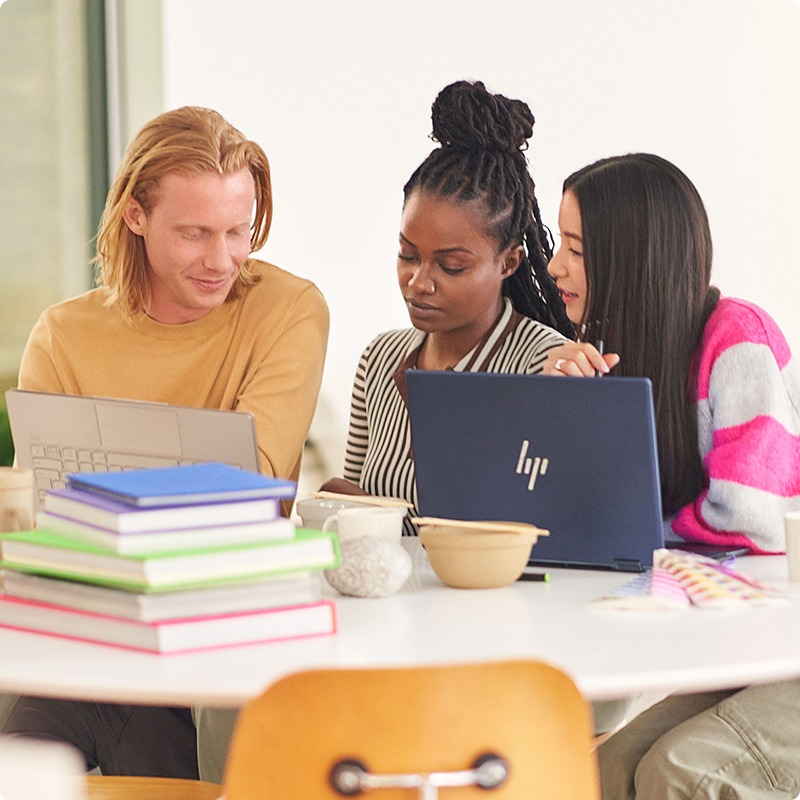 Alcune persone sedute a un tavolo osservano un PC